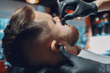 Berber dükkanında oturan şık bir adam.