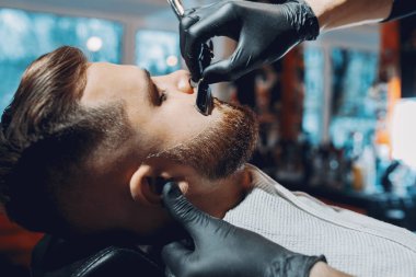 Berber dükkanında oturan şık bir adam.