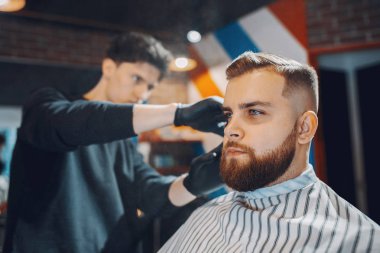 Berber dükkanında oturan şık bir adam.