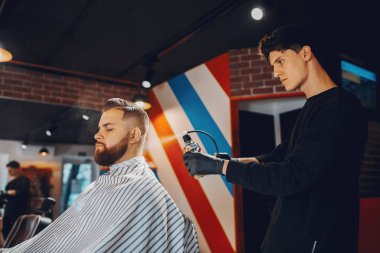 Berber dükkanında oturan şık bir adam.