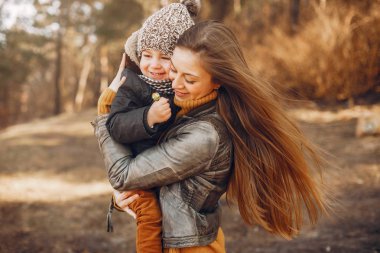 Anne ve oğlu yaz parkında oynuyorlar.