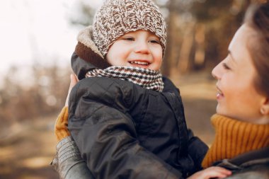 Anne ve oğlu yaz parkında oynuyorlar.