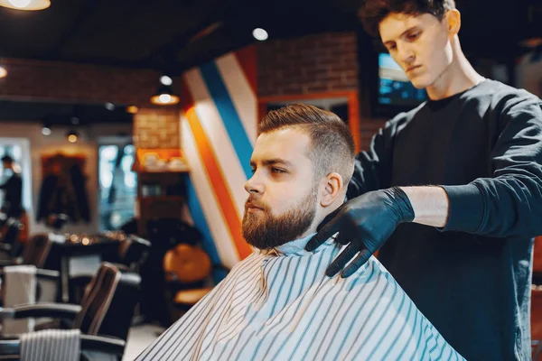 Stilvoller Mann sitzt in einem Friseurladen — Stockfoto