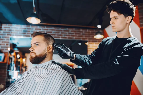 Stilvoller Mann sitzt in einem Friseurladen — Stockfoto