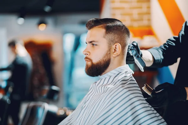 Stilvoller Mann sitzt in einem Friseurladen — Stockfoto