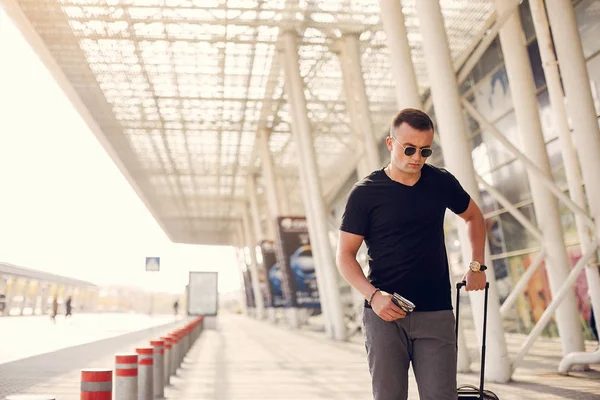 Schöner Mann, der auf einem Flughafen steht — Stockfoto