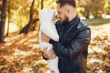 Sonbahar parkında oynayan sevimli bir aile.