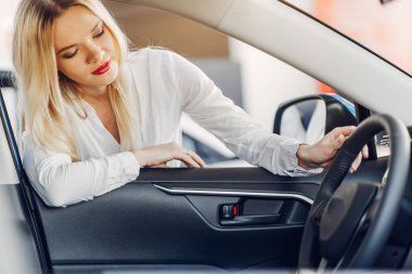 Bir araba galerisinde şık ve zarif bir kadın.