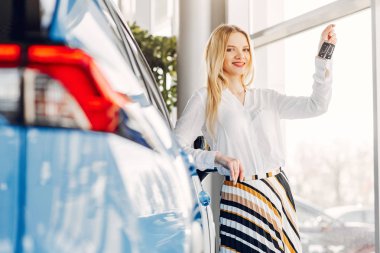 Bir araba galerisinde şık ve zarif bir kadın.