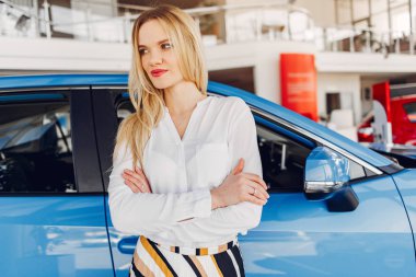 Bir araba galerisinde şık ve zarif bir kadın.