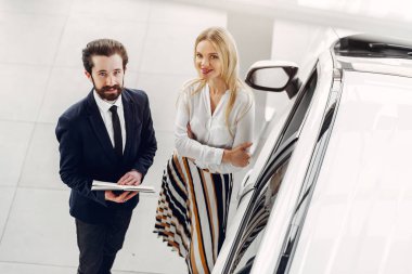 Bir araba galerisinde şık ve zarif bir kadın.