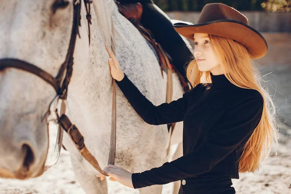 Menina elegante com um cavalo em um rancho — Fotografia de Stock