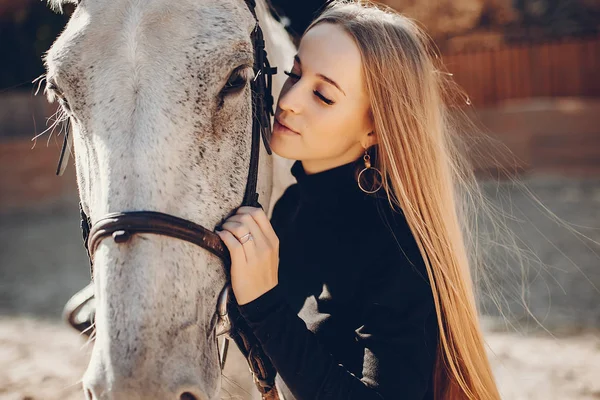 Elegants meisje met een paard in een ranch — Stockfoto
