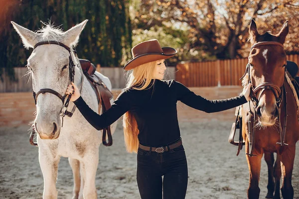 Elegants meisje met een paard in een ranch — Stockfoto