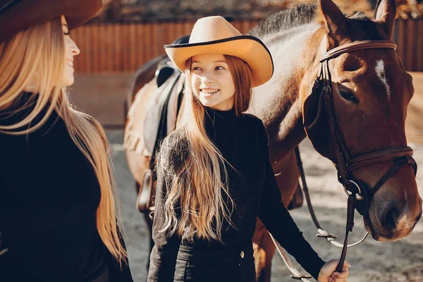 Meninas elegantes com um cavalo em um rancho — Fotografia de Stock