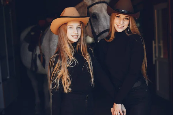 Elegante meisjes met een paard in een ranch — Stockfoto