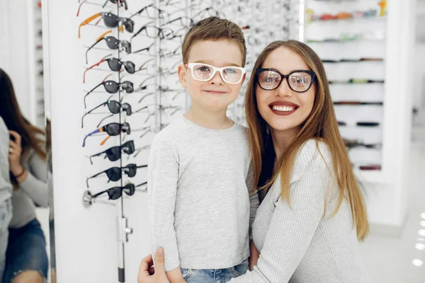 Madre con hijo pequeño en la tienda de gafas — Foto de Stock