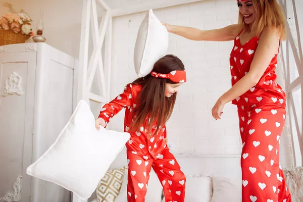 Schattige moeder en dochter thuis in een pyjama — Stockfoto