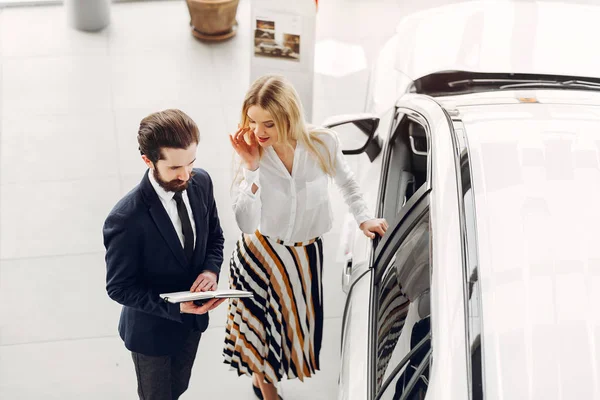 Bir araba galerisinde şık ve zarif bir kadın.