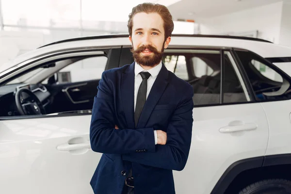 Hombre guapo y elegante en un salón de coches —  Fotos de Stock