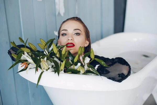 Stylish and beautiful girl lies in the bathroom — Stock Photo, Image