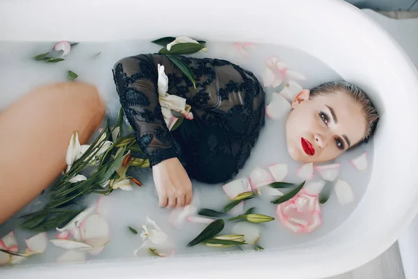 Stylish and beautiful girl lies in the bathroom — Stock Photo, Image