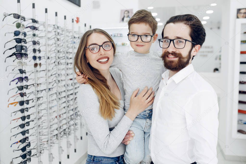 Family with little son in the glasses store