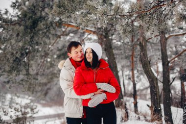 Sevgili çift kış parkında yürüyor.