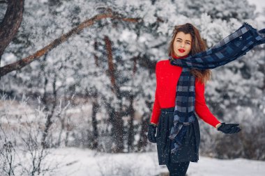 Kış parkında zarif ve genç bir kız.