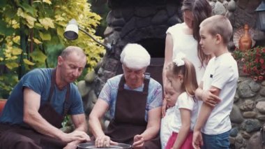 Torunları olan büyükanne ve büyükbabalar çömlekçilikte sürahi yapar