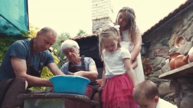 Torunları olan büyükanne ve büyükbabalar çömlekçilikte sürahi yapar