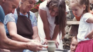 Torunları olan büyükanne ve büyükbabalar çömlekçilikte sürahi yapar