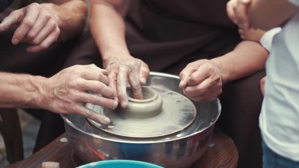 Grandparents with a grandchildren make jug in pottery — Stock Video