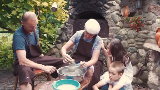 Grootouders met een kleinkinderen maken kruik in aardewerk — Stockvideo