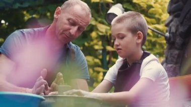 Bir torunu ile Büyükbaba çömlek sürahi yapmak