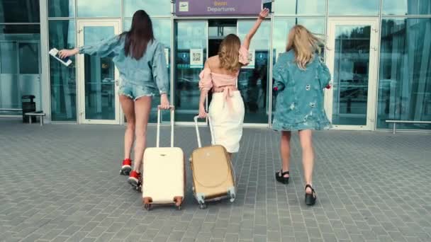 Meninas caminhando para a entrada do aeroporto com bagagem — Vídeo de Stock