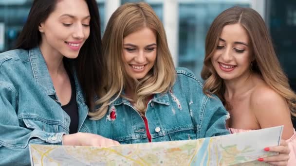 Meisjes kijken naar de kaart in de buurt van de luchthaven — Stockvideo
