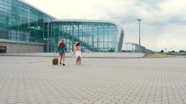 Meisjes in volle hoogte lopen naast de luchthaven — Stockvideo