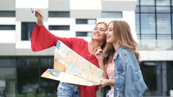 Flickor som håller karta stående nära modern byggnad — Stockvideo