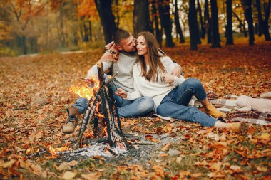 Zarif çift sonbahar parkında vakit geçiriyor.