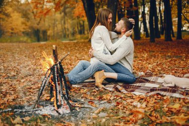 Zarif çift sonbahar parkında vakit geçiriyor.