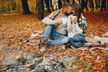 Zarif çift sonbahar parkında vakit geçiriyor.