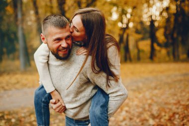 Zarif çift sonbahar parkında vakit geçiriyor.