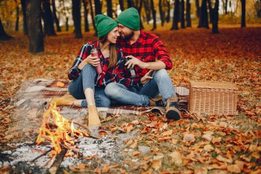 Zarif çift sonbahar parkında vakit geçiriyor.