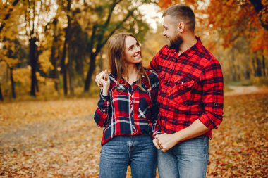 Zarif çift sonbahar parkında vakit geçiriyor.