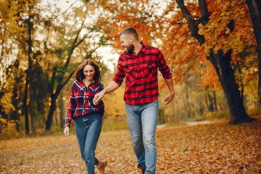 Zarif çift sonbahar parkında vakit geçiriyor.