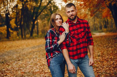 Zarif çift sonbahar parkında vakit geçiriyor.