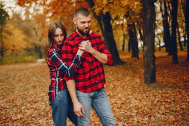 Zarif çift sonbahar parkında vakit geçiriyor.