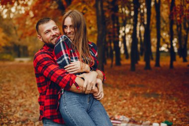 Zarif çift sonbahar parkında vakit geçiriyor.