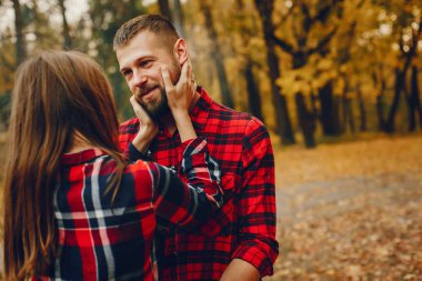 Zarif çift sonbahar parkında vakit geçiriyor.